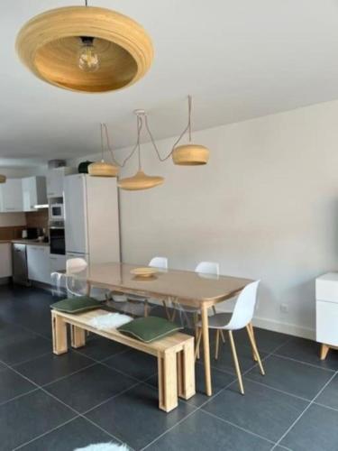 une salle à manger avec une table et des chaises en bois dans l'établissement Villa neuve et moderne à 250 m de l'océan, classée 3 étoiles, à Lacanau