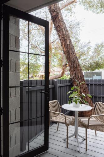 a patio with a table and chairs and a tree at MAC Richmond by Melbourne Apartment Collection in Melbourne