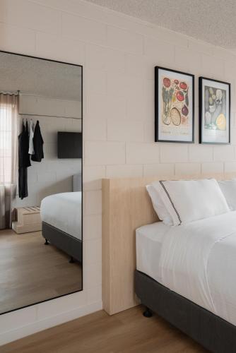 a bedroom with a large mirror and a bed at MAC Richmond by Melbourne Apartment Collection in Melbourne