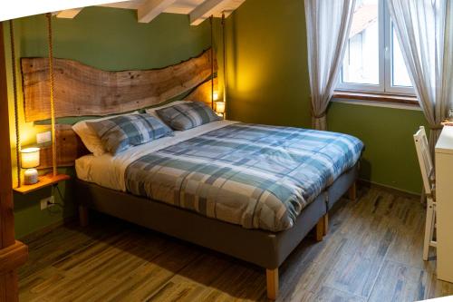 a bedroom with a bed with a wooden headboard at LOCANDA VECCHIO NOVECENTO in Grosso