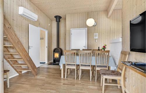a dining room with a table and chairs and a fireplace at Awesome Home In Faaborg With Sauna in Åstrup