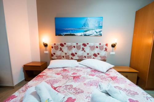 a bedroom with a bed with a floral bedspread at B&B Profumi di Sicilia in Valderice