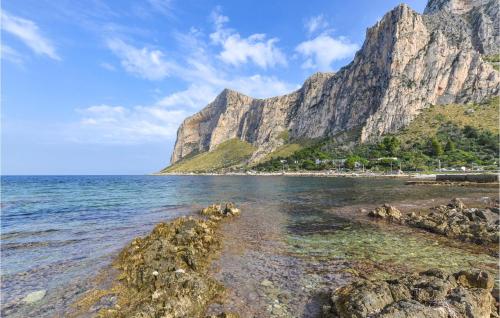 a rocky beach with a mountain in the background at Mages in Casteldaccia