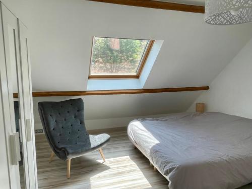 - une chambre avec un lit et une chaise à côté d'une fenêtre dans l'établissement Maison Côte Et Champs, à Doudelainville