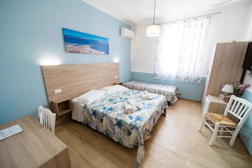 a bedroom with a bed and a table and a desk at B&B Profumi di Sicilia in Valderice