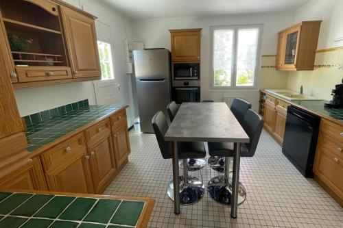 une cuisine avec une table avec des chaises et un réfrigérateur dans l'établissement Beautiful and spacious house near the sea, à Fréjus