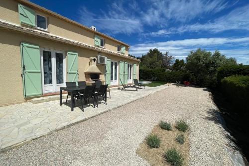 un patio avec une table et des chaises devant une maison dans l'établissement Beautiful and spacious house near the sea, à Fréjus