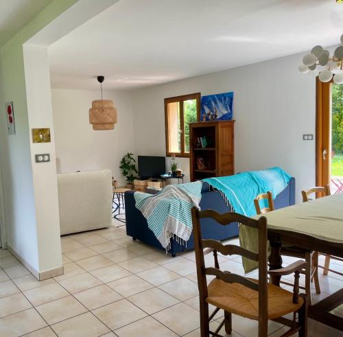 un salon avec un lit et une table dans l'établissement Maison Côte Et Champs, à Doudelainville