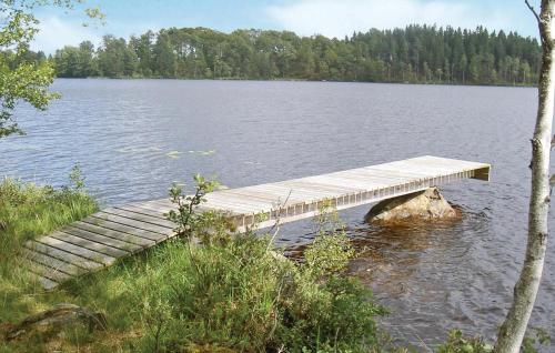 a wooden dock in the middle of a lake at Amazing Home In Lidhult With Wifi in Bassarås