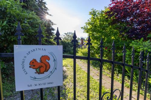 a sign on a fence with a squirrel on it at Kismókus Apartman in Eger