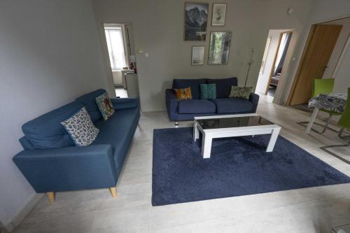 - un salon avec deux canapés bleus et une table basse dans l'établissement i-love-colmar - Les Remparts - Parking, à Colmar