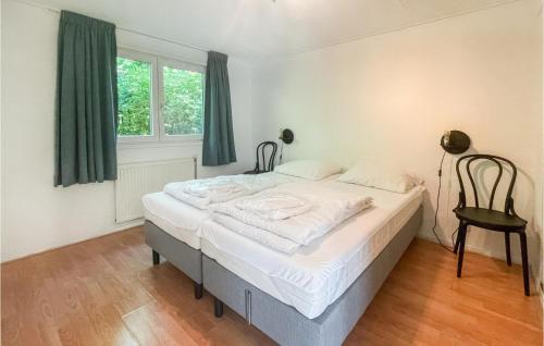 a bedroom with a bed and a chair in it at Lovely StaCaravan In Putten With Wifi in Putten