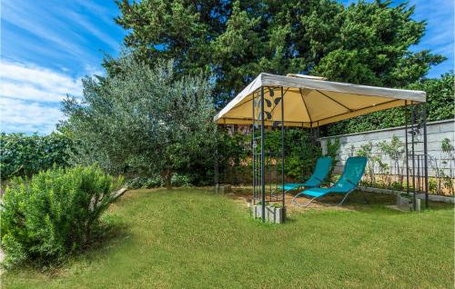 un cenador con dos sillas debajo en un patio en 2 Bedroom Awesome Apartment In Omisalj, en Omišalj