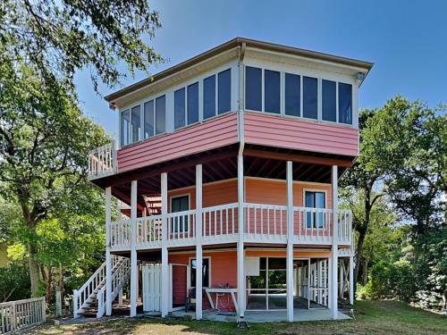 a large house with a wrap around porch at Just Another Day in Paradise in Surf City