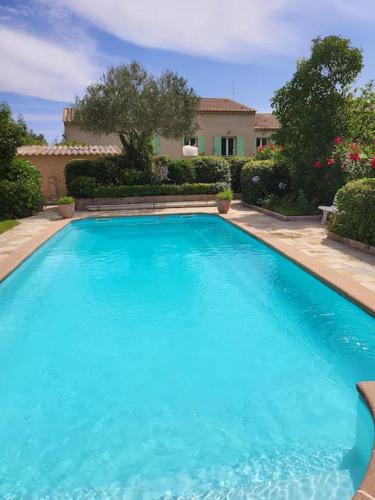 une grande piscine bleue devant une maison dans l'établissement Jolie maison familiale Golfe de Saint-Tropez, à Gassin