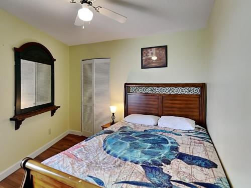 a bedroom with a bed with a turtle comforter at Just Another Day in Paradise in Surf City
