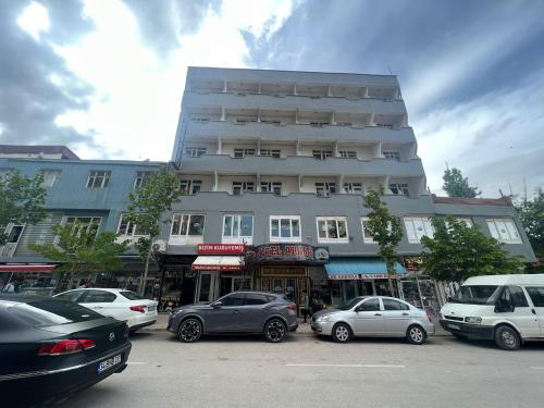 Un gran edificio con coches aparcados delante. en Hotel Ararat, en Doğubayazıt