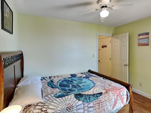 a bedroom with a bed and a ceiling fan at Just Another Day in Paradise in Surf City