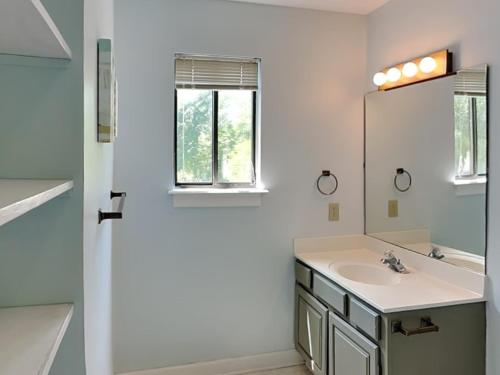 a white bathroom with a sink and a mirror at Just Another Day in Paradise in Surf City