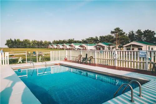 a large swimming pool with a white fence at Island Life Cottages in Brackley Beach