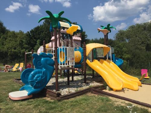 a playground with a slide in the grass at Chata 115 Tatralandia in Liptovský Mikuláš