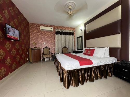 a hotel room with a large bed with a red blanket at HOTEL TOURIST INN in Lahore