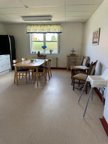 Un comedor con mesas y sillas y una ventana. en Mellerum på Österlen, en Simrishamn