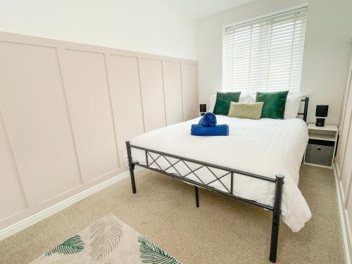 a bedroom with a large bed with green pillows at Emerald House -3 Bed - Free Parking in Ferrybridge