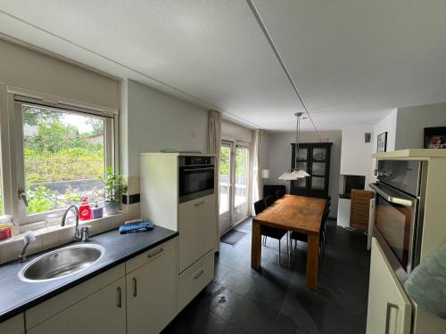 a kitchen with a sink and a table in it at Vakantiehuis midden in de natuur in Halle