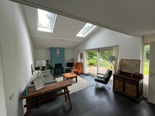 a living room with skylights and a table and chairs at Vakantiehuis midden in de natuur in Halle