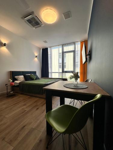 a room with a bed and a table with a green chair at Hotel Apart in Warsaw