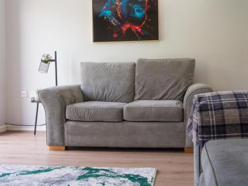a grey couch in a living room with a painting at Emerald House -3 Bed - Free Parking in Ferrybridge