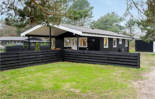 a black house with a fence in front of it at Amazing Home In Martofte With Wifi in Martofte