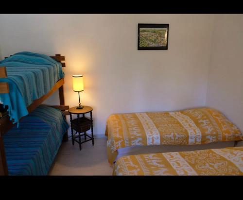 une chambre avec deux lits et une table avec une lampe dans l'établissement Appart sunshine, à Sainte-Tulle