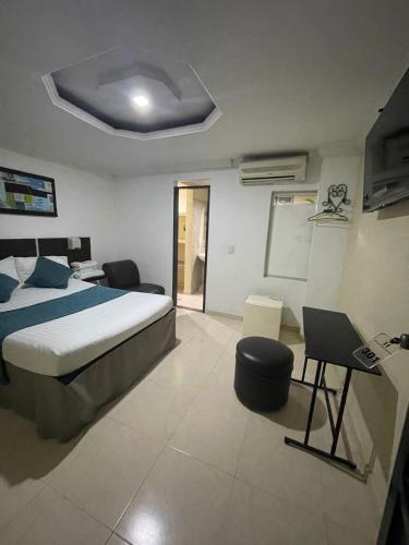 a bedroom with a bed and a desk in it at Hotel Plaza Norte Cali in Cali