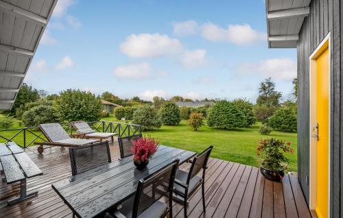 a wooden deck with chairs and a table with flowers at Amazing Home In Allingåbro With Wifi in Allingåbro