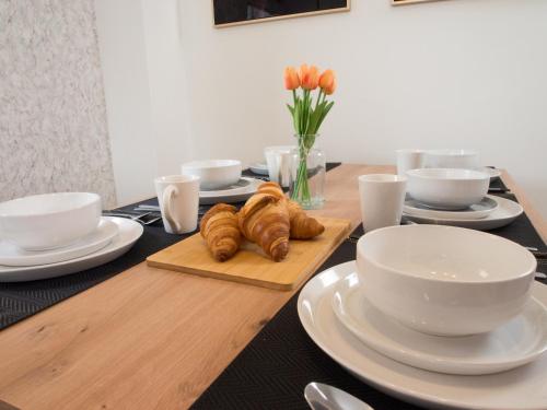 a table with white dishes and croissants on it at Emerald House -3 Bed - Free Parking in Ferrybridge