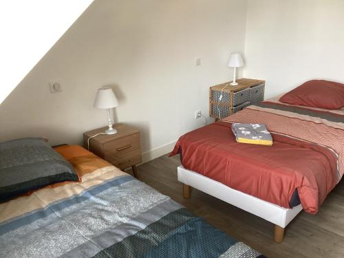 une chambre avec deux lits et deux tables de nuit dans l'établissement Les Halles centre ville parking en option, à Étretat