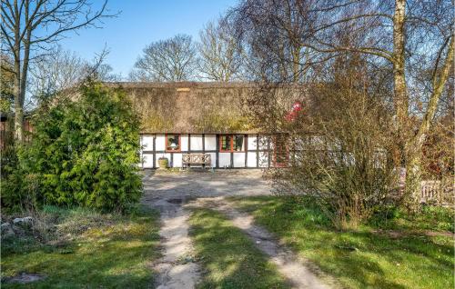 an old house in the middle of a yard at Gorgeous Home In Ørsted With Kitchen in Ørsted