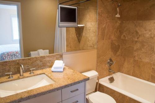 TV y baño con lavabo y aseo. en Cottonwood Condo 1473, en Ketchum