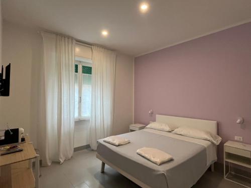 a white bedroom with a bed and a window at Bed and coffee Rooms Portoferraio in Portoferraio