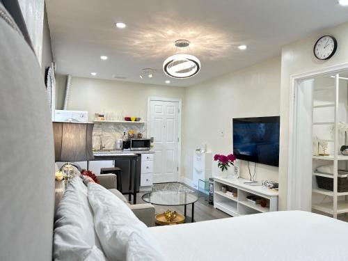 a living room with a couch and a tv at Modern Lux Family Rooms - KingBed - Near Sheppard W Station Toronto in Toronto