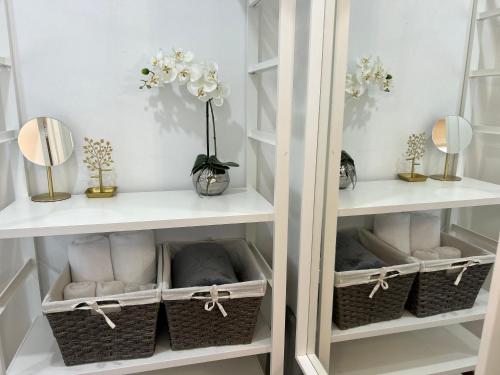 a white closet with baskets and mirrors and flowers at Modern Lux Family Rooms - KingBed - Near Sheppard W Station Toronto in Toronto