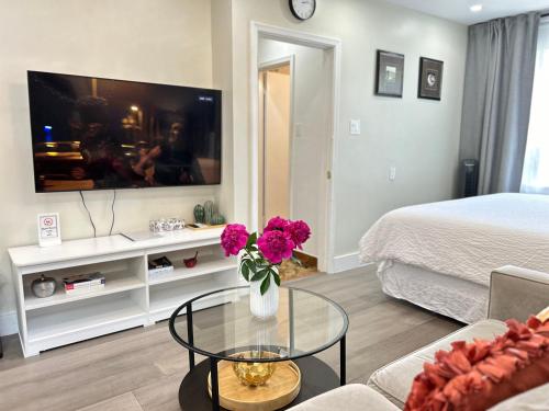 a living room with a vase of flowers on a table at Modern Lux Family Rooms - KingBed - Near Sheppard W Station Toronto in Toronto