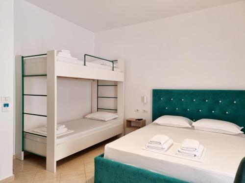 two beds in a room with a bunk bed at Arte Apartment in Sarandë