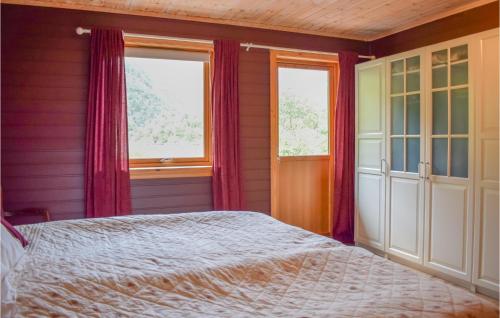 a bedroom with a bed and two windows at Amazing Home In Matredal With Kitchen in Haugsvær