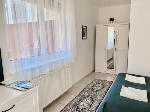 ケストヘイにあるVilla Lillybeth Garden Roomsのベッドルーム1室(ベッド1台、窓、鏡付)