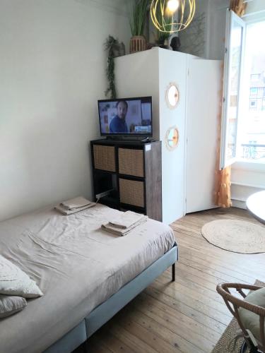 une chambre avec un lit avec une télévision dessus dans l'établissement Studio le Métropole Centre ville, à Deauville
