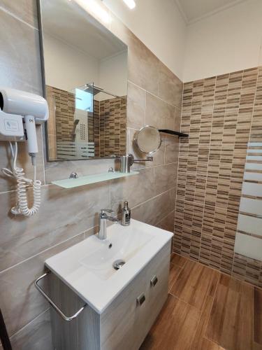 a bathroom with a sink and a mirror at Joó Apartman in Balatonszabadi