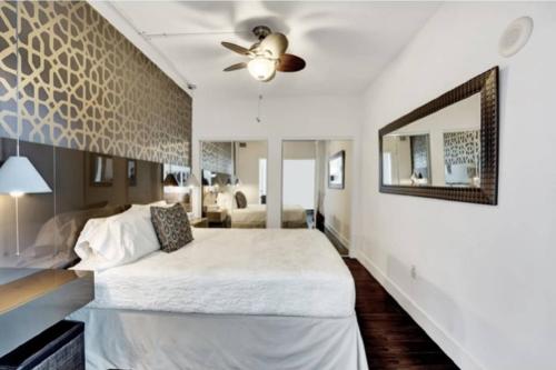 a bedroom with a large bed and a mirror at Casa Costa 309N 1 Bedroom, Pools, Jacuzzi, Beach, Shops & Dog Friendly in Boynton Beach